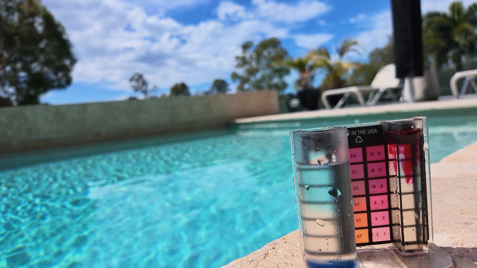 Testing pool water chemistry poolside with a chemical test kit